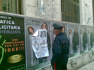 Un carabiniere davanti al manifesto